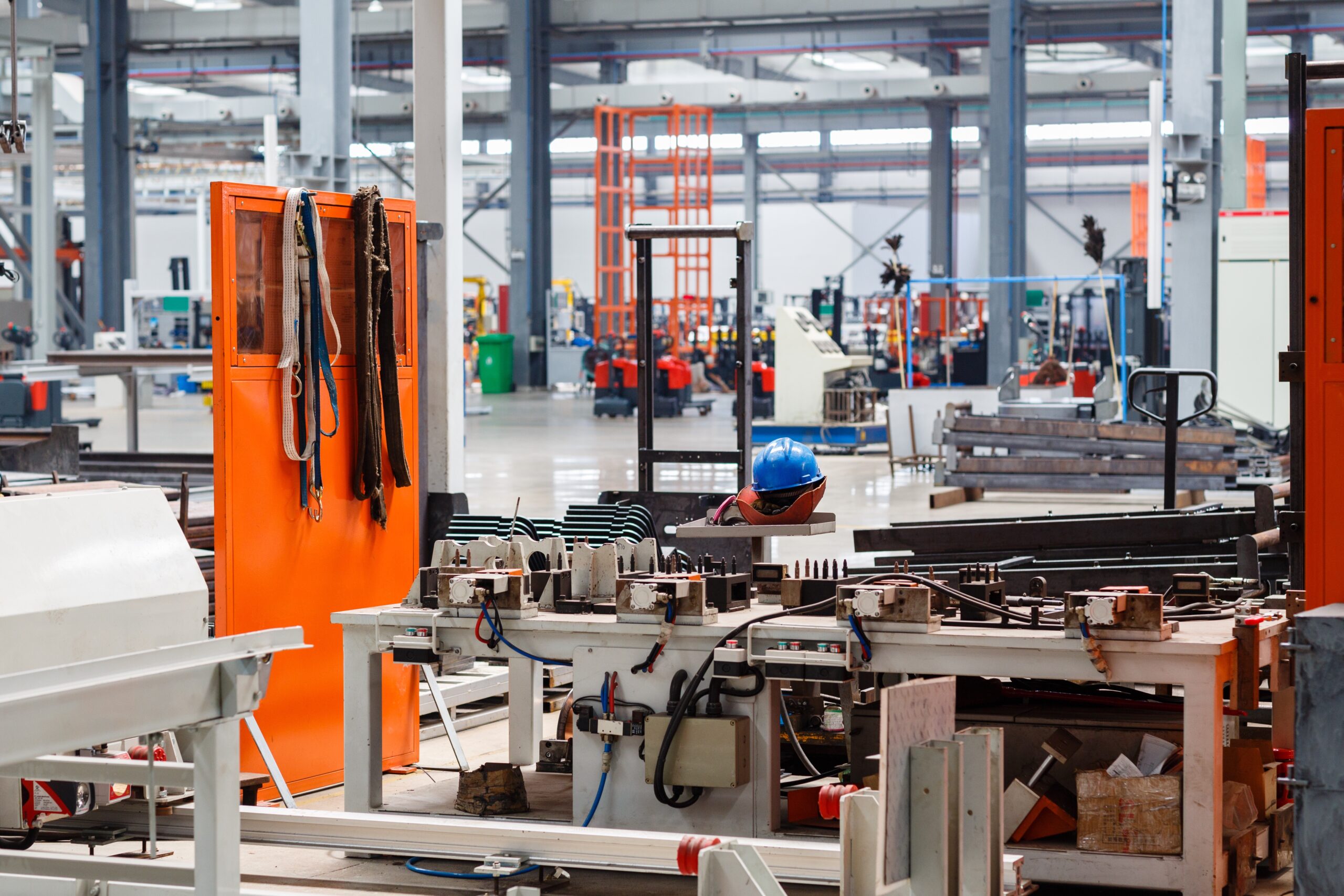 Idle industrial equipment on a factory floor awaiting repair due to reactive maintenance delays